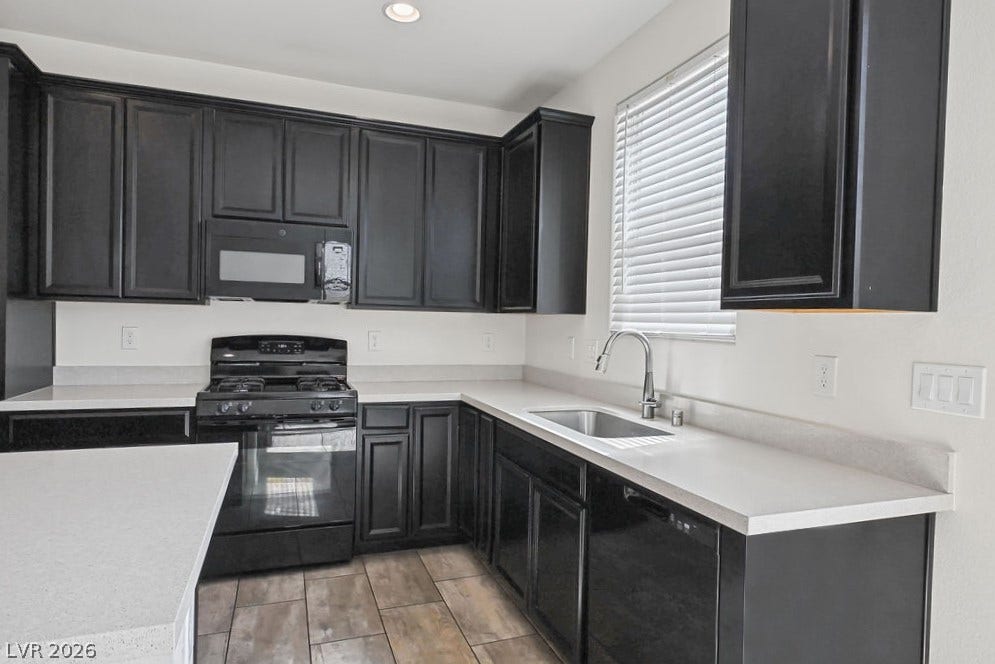 Dark cabinetry contrasts beautifully with light solid-surface countertops in this modern cooking space.