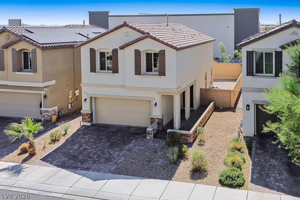 A classic two-story exterior showcases detailed stonework, window shutters, and an integrated garage.