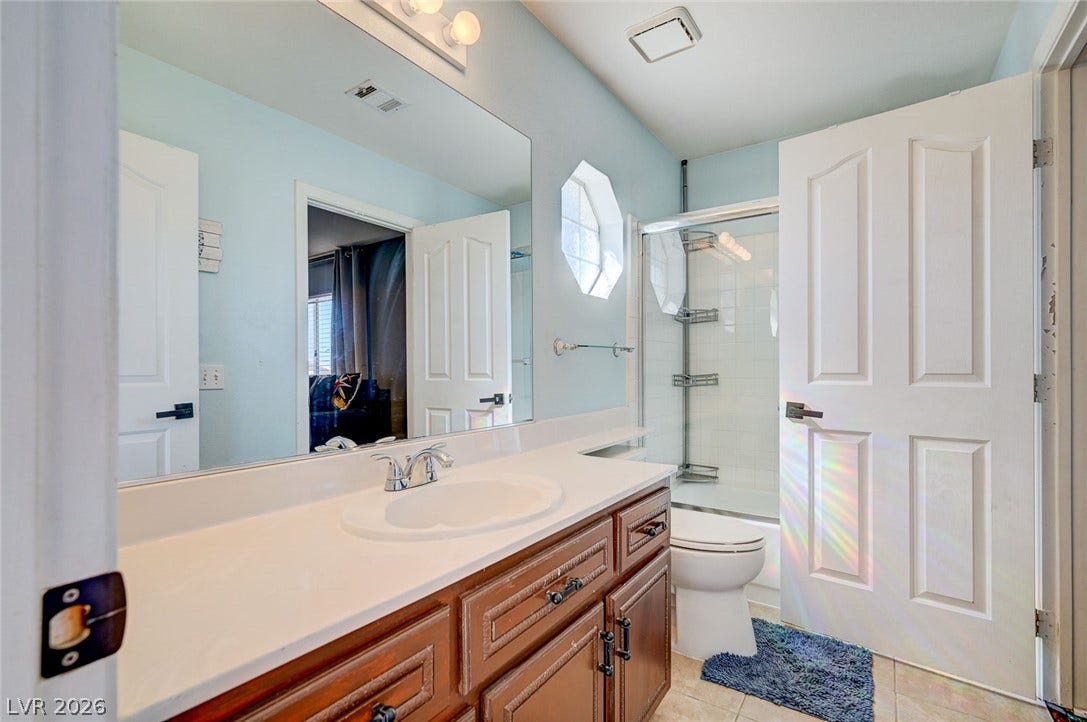2722 Aspen Wood Avenue, Henderson, NV 89074 Smooth solid-surface countertops pair with timeless wood cabinetry in this well-appointed bathroom.
