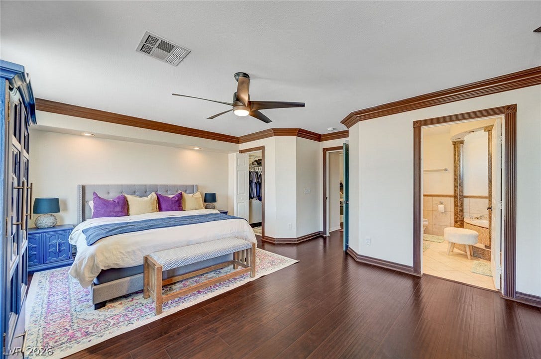 2722 Aspen Wood Avenue, Henderson, NV 89074 Rich hardwood floors and classic crown molding elevate this spacious main bedroom suite.