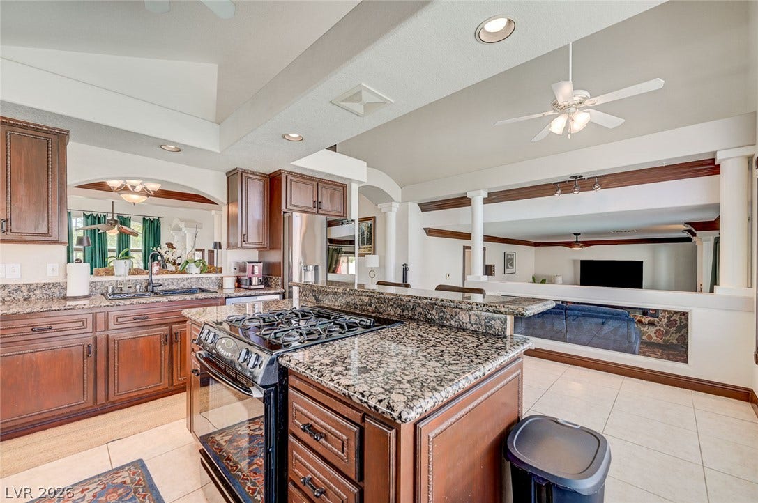 2722 Aspen Wood Avenue, Henderson, NV 89074 Polished granite countertops and classic wood cabinetry define this open multi-level kitchen design.
