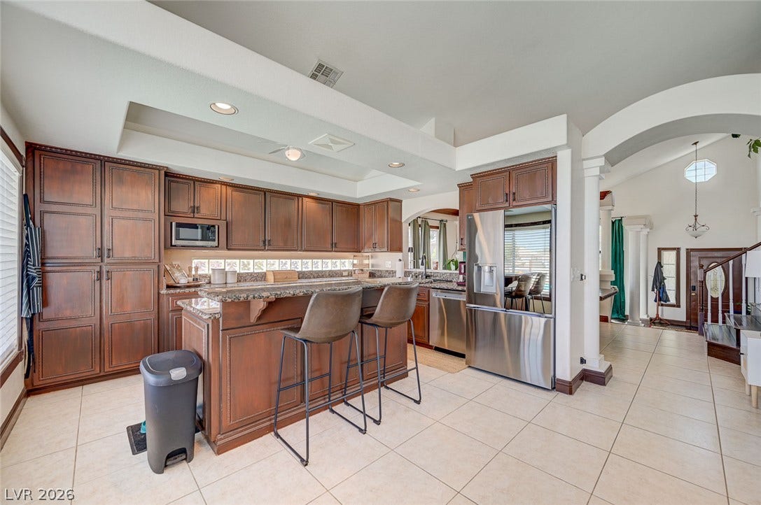 2722 Aspen Wood Avenue, Henderson, NV 89074 Rich wood cabinetry and expansive tile floors anchor this beautifully designed open culinary space.