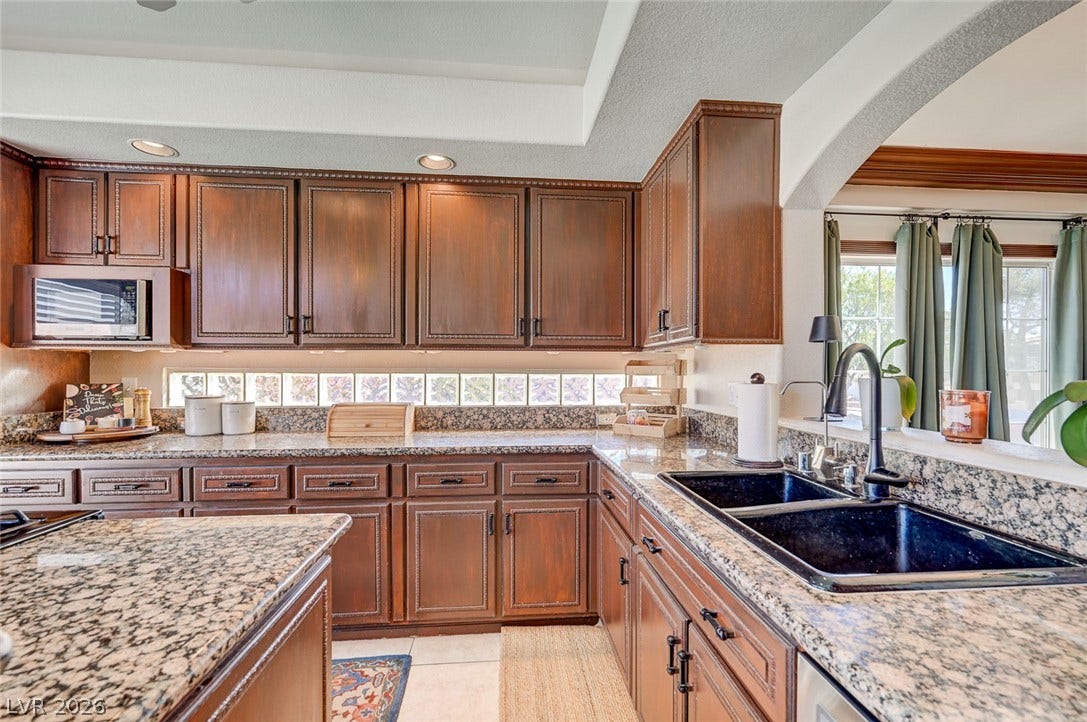 2722 Aspen Wood Avenue, Henderson, NV 89074 Rich wood cabinetry paired with granite countertops establishes a warm tone in the kitchen.