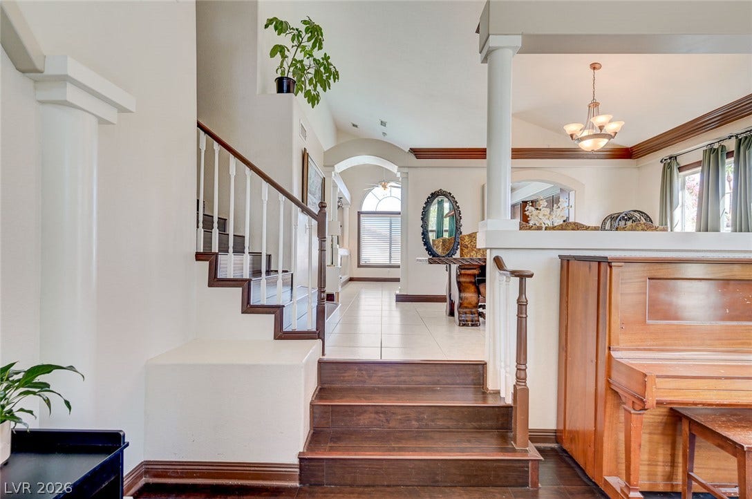 2722 Aspen Wood Avenue, Henderson, NV 89074 Gleaming hardwood steps ascend to an open-concept living area under soaring vaulted ceilings.