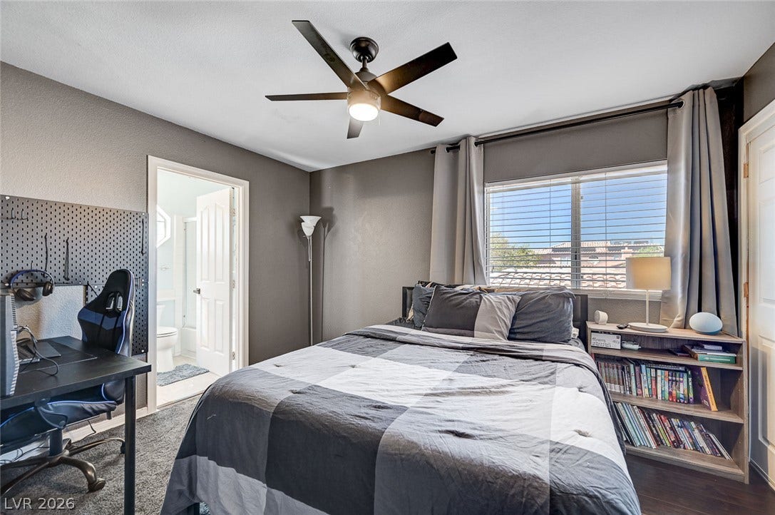 2722 Aspen Wood Avenue, Henderson, NV 89074 An inviting bedroom features plush carpeting, a large window, and direct access to a private bathroom.