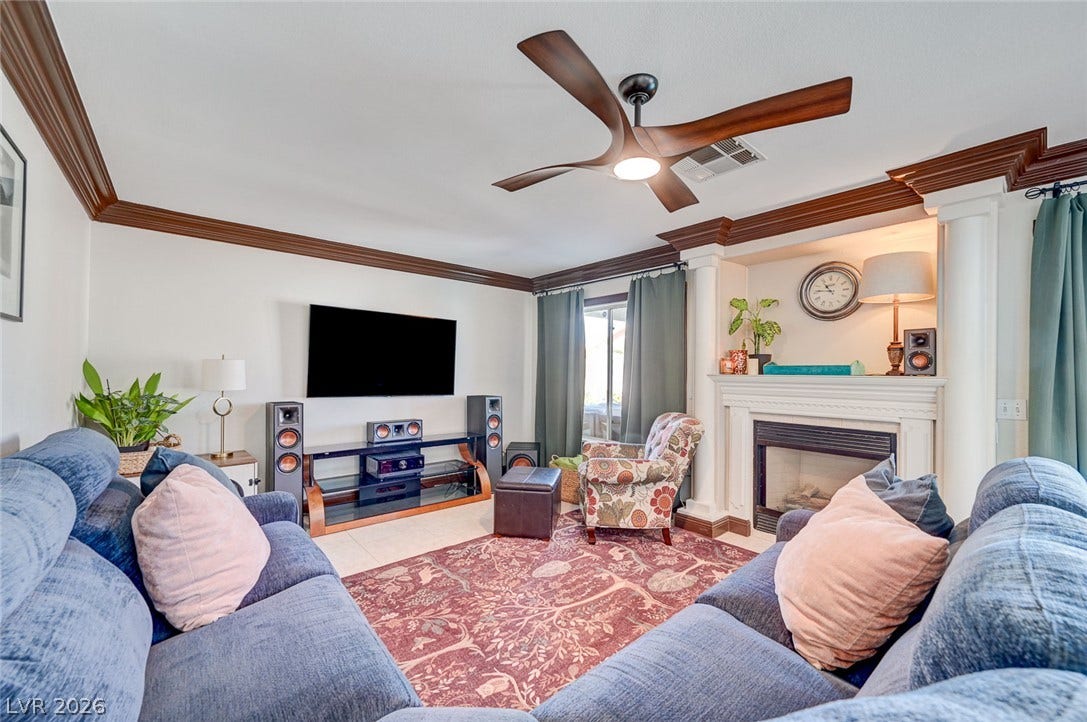 2722 Aspen Wood Avenue, Henderson, NV 89074 Elegant crown molding and a classic fireplace create a cozy, welcoming atmosphere in this spacious room.