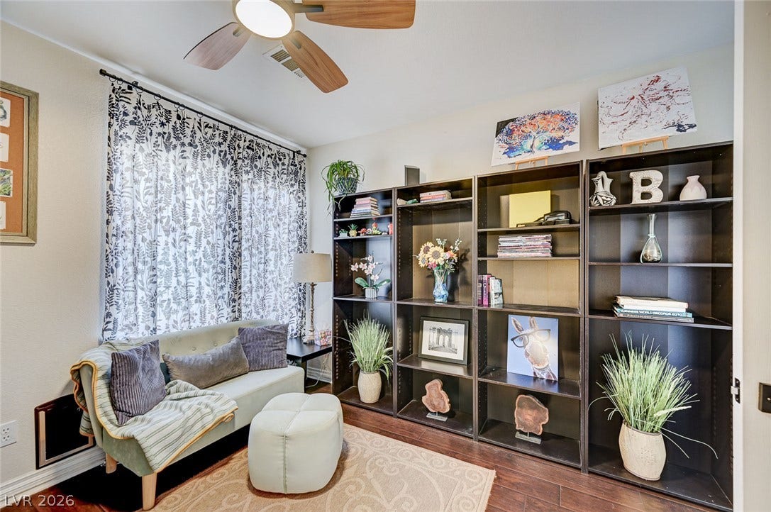 2722 Aspen Wood Avenue, Henderson, NV 89074 Rich hardwood flooring anchors this versatile space, illuminated by natural light from a large window.