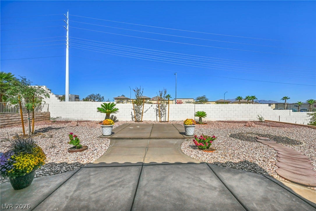 10020 Villa Ridge Drive, Las Vegas, NV 89134 Concrete walkways cross through a low-maintenance gravel yard enclosed by a privacy wall.