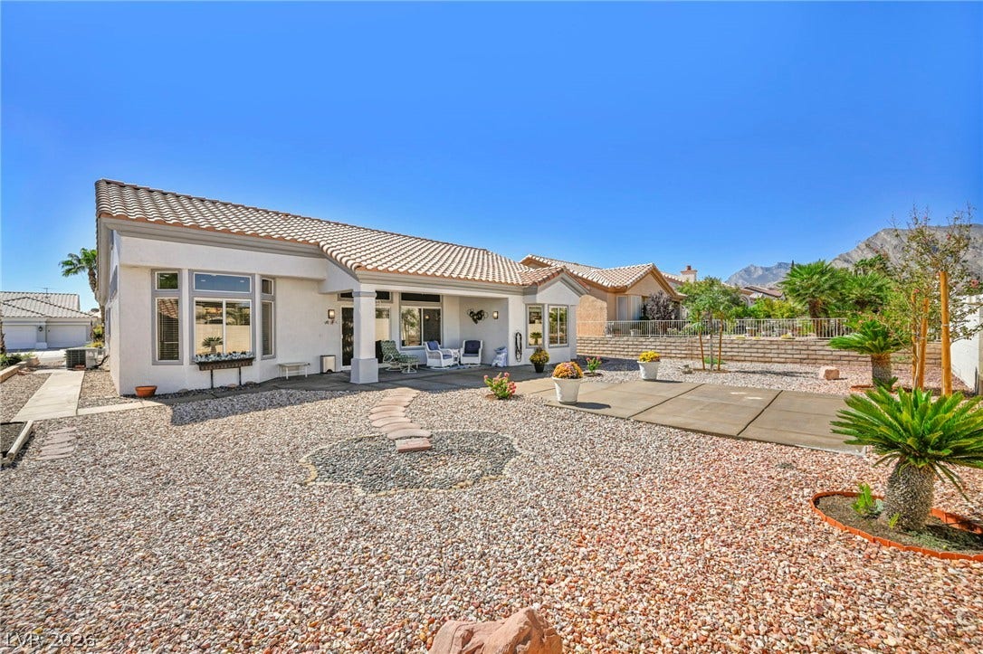 10020 Villa Ridge Drive, Las Vegas, NV 89134 Low-maintenance desert landscaping surrounds this tile-roofed home under clear blue skies.