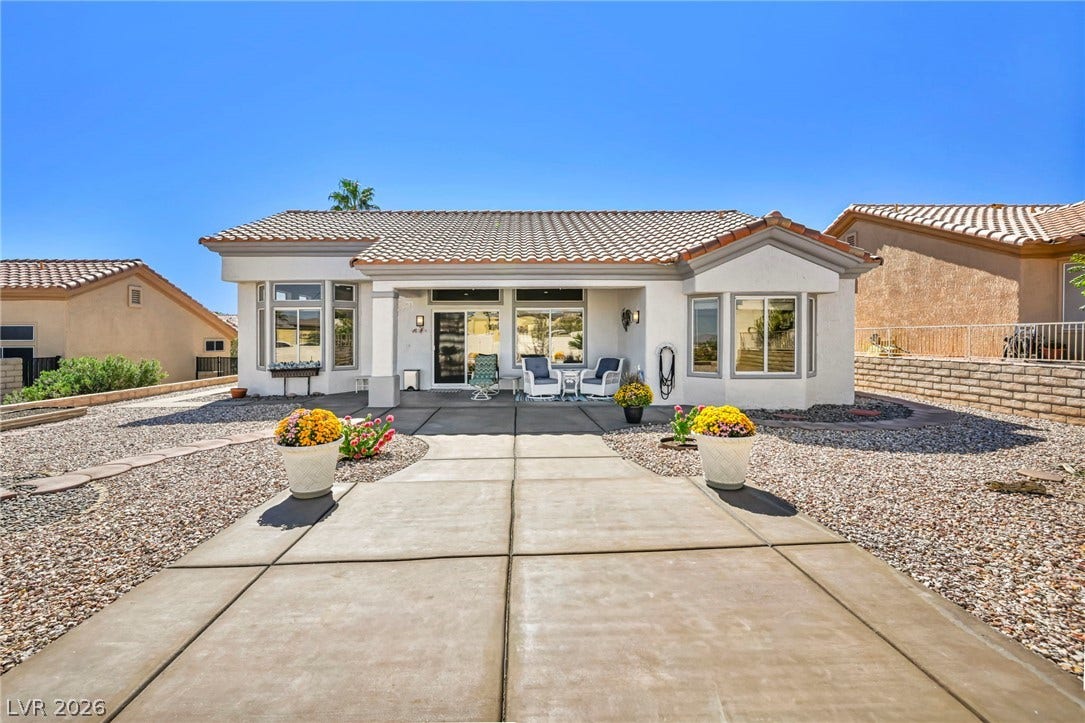 10020 Villa Ridge Drive, Las Vegas, NV 89134 A wide concrete pathway leads directly to the covered patio of this classic stucco home.
