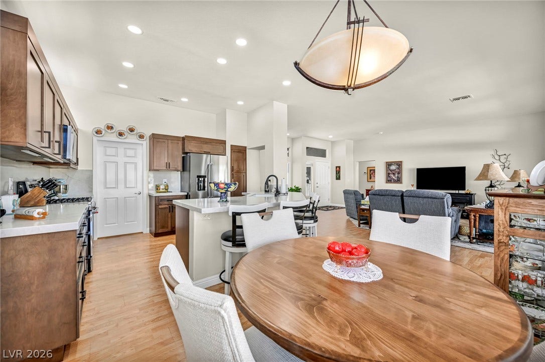 10020 Villa Ridge Drive, Las Vegas, NV 89134 Warm wood flooring and recessed lighting connect the dining area to an open kitchen.