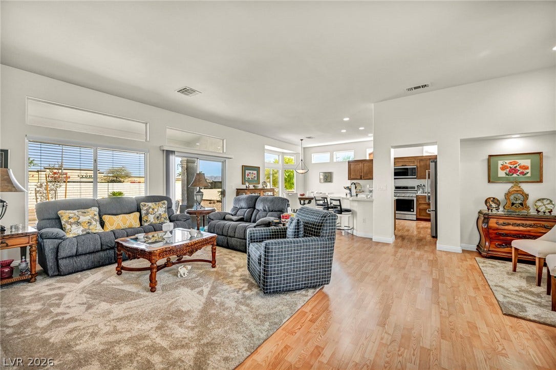 10020 Villa Ridge Drive, Las Vegas, NV 89134 Polished wood floors and tall windows define this airy open-concept living space.