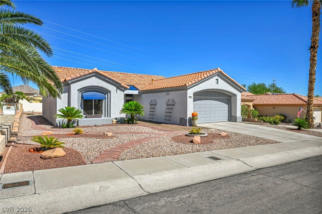 10020 Villa Ridge Drive, Las Vegas, NV 89134 Spanish tile roofing and desert-friendly landscaping create exceptional curb appeal under wide blue skies.