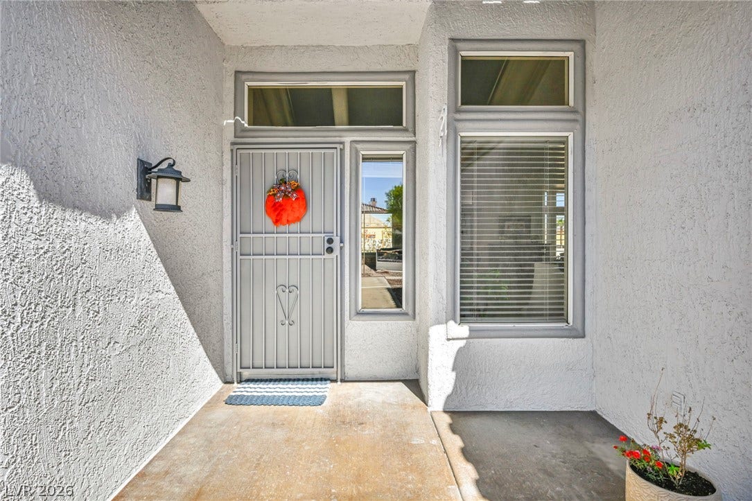 10020 Villa Ridge Drive, Las Vegas, NV 89134 An inviting stucco entryway features a secure gated front door and large windows.