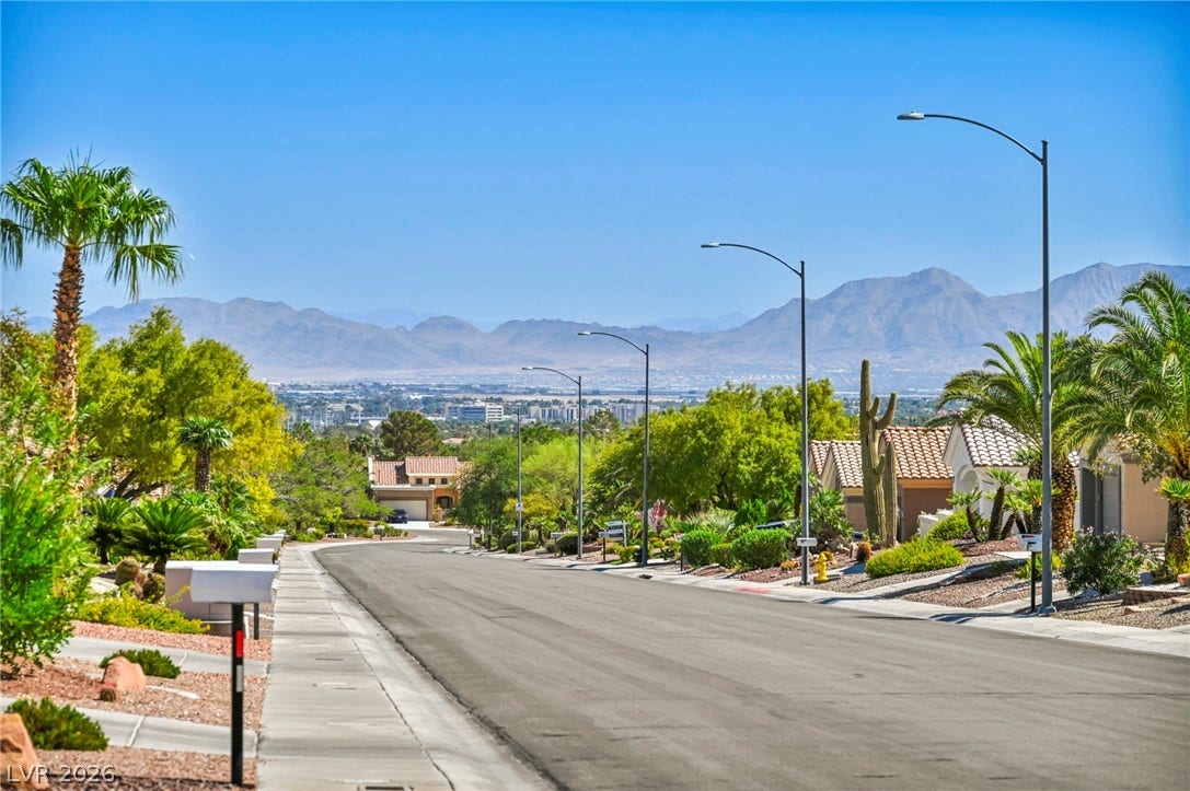 10020 Villa Ridge Drive, Las Vegas, NV 89134 A quiet suburban street winds down toward a panoramic vista of distant desert mountains.