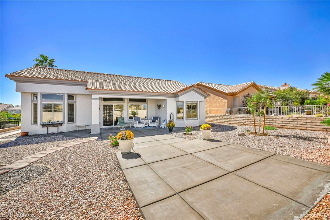 10020 Villa Ridge Drive, Las Vegas, NV 89134 An inviting concrete patio overlooks the low-maintenance desert landscaping under a clear blue sky.