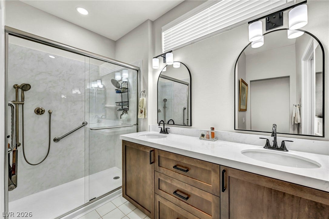 10020 Villa Ridge Drive, Las Vegas, NV 89134 A spacious vanity with dual sinks sits opposite a modern walk-in glass shower.