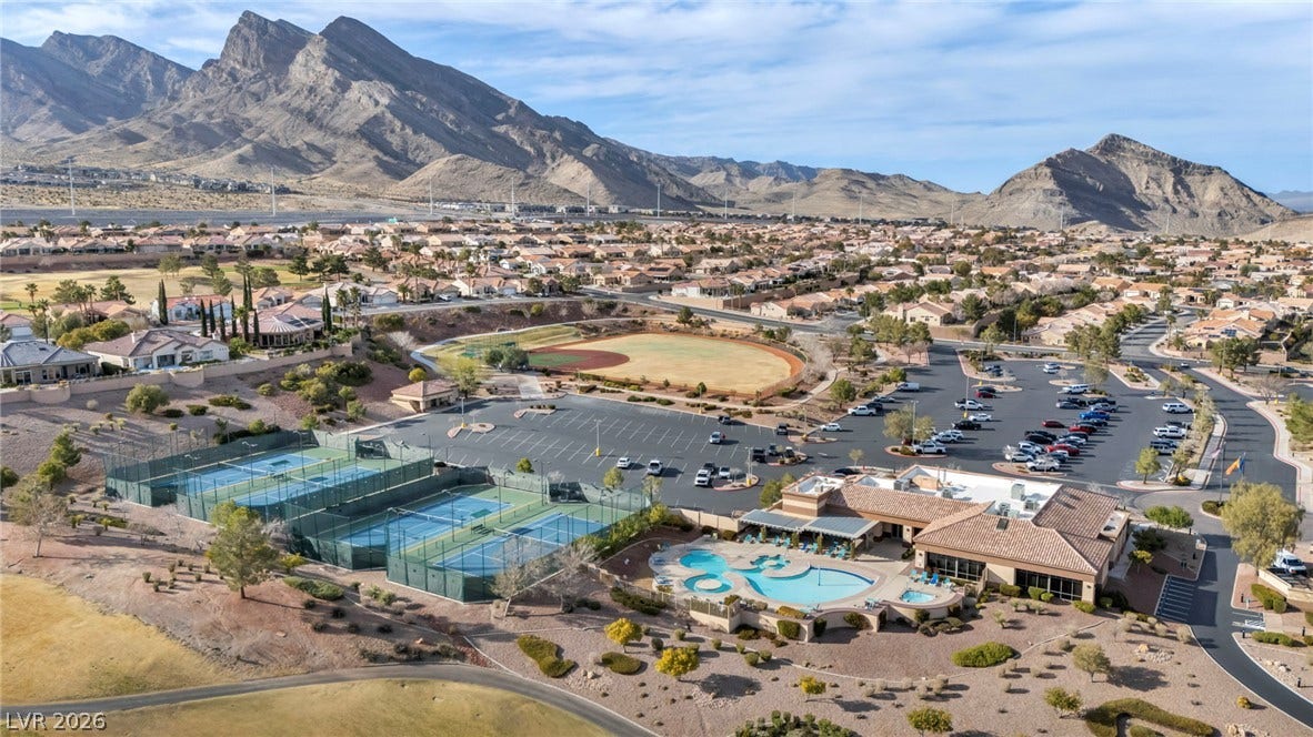 10020 Villa Ridge Drive, Las Vegas, NV 89134 Dramatic mountain vistas rise behind a community recreation center with tennis courts and a pool.