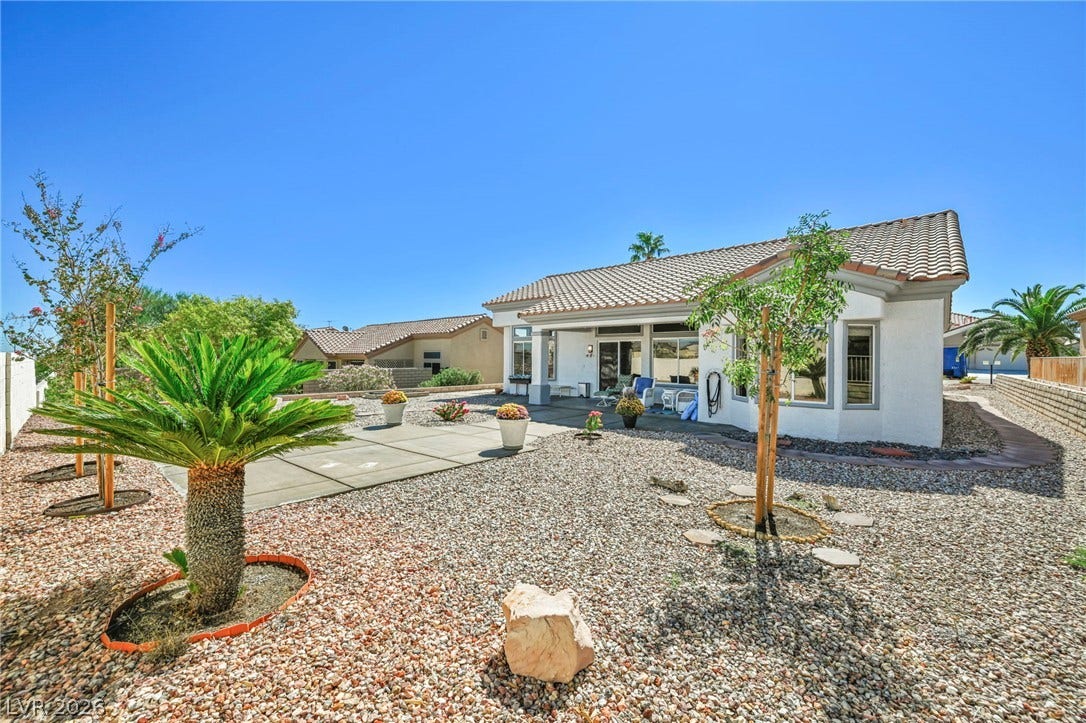 10020 Villa Ridge Drive, Las Vegas, NV 89134 Low-maintenance desert landscaping frames a covered back patio under a tile roof.
