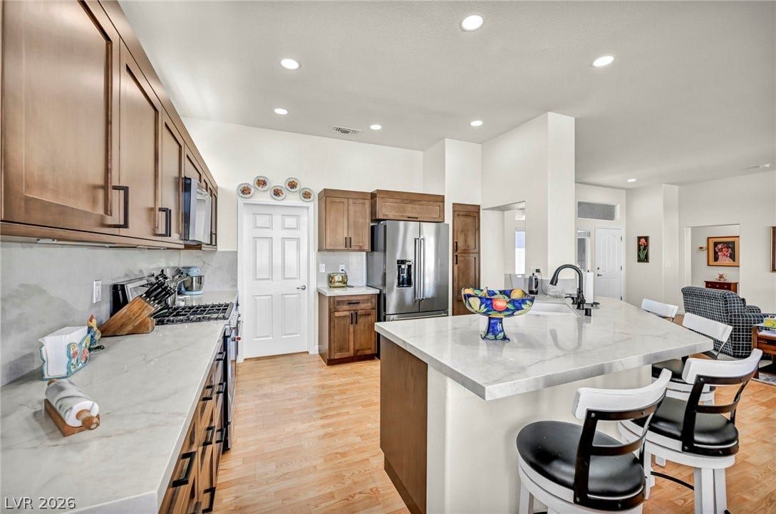 10020 Villa Ridge Drive, Las Vegas, NV 89134 Gleaming stone countertops and warm wood flooring define this open culinary space.
