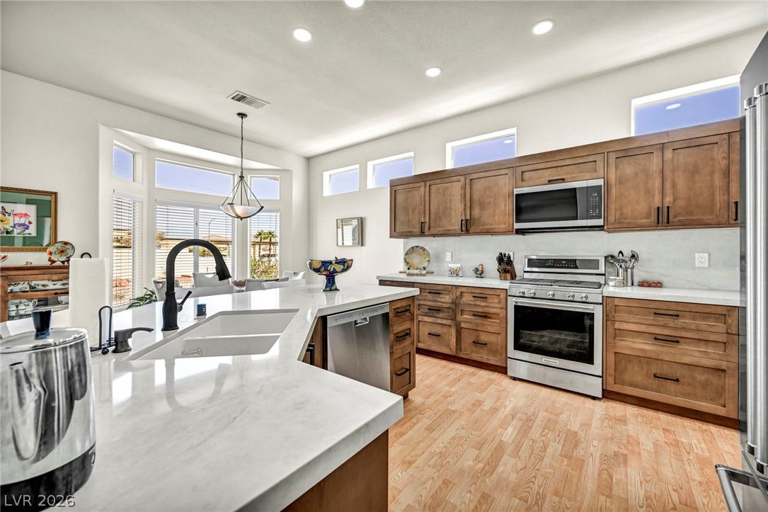 10020 Villa Ridge Drive, Las Vegas, NV 89134 Rich wood cabinetry contrasts beautifully with white countertops and light-toned flooring.