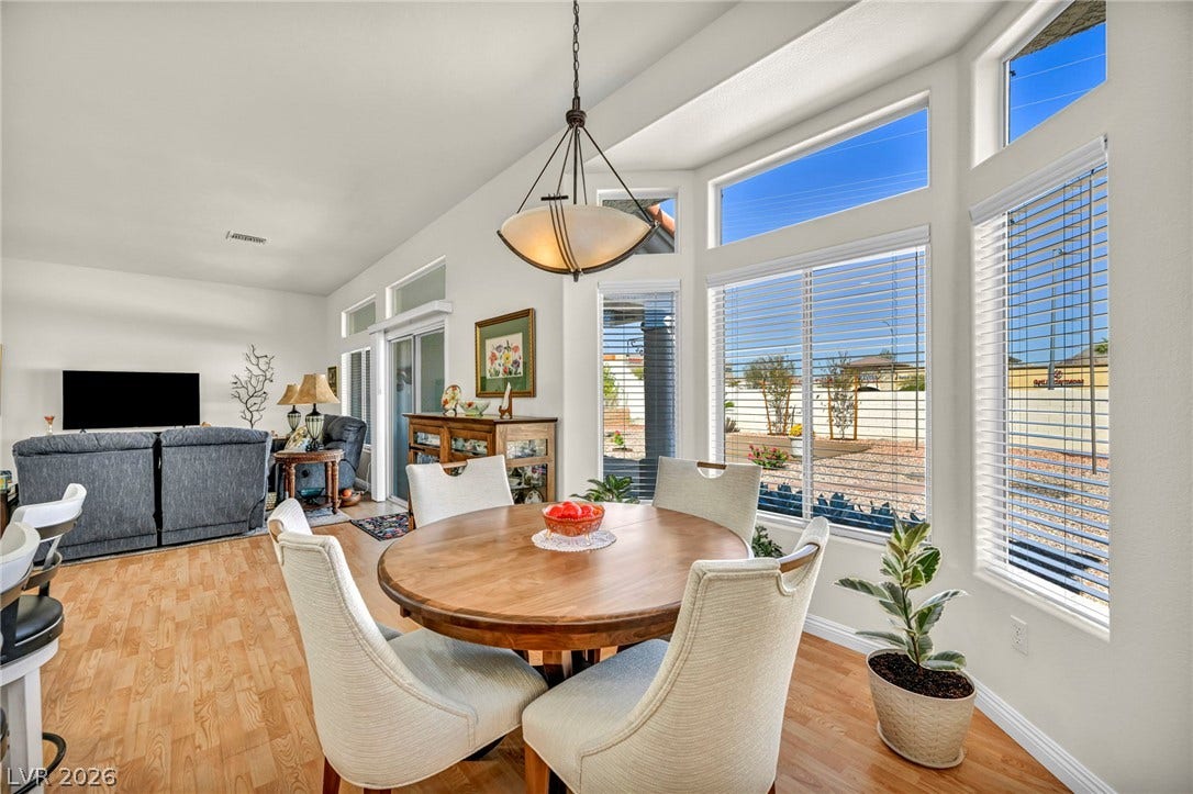 10020 Villa Ridge Drive, Las Vegas, NV 89134 Laminate flooring and high ceilings elevate this open dining space illuminated by tall windows.