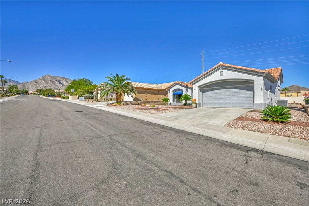 10020 Villa Ridge Drive, Las Vegas, NV 89134 Spanish tile roofs and stucco exteriors line this quiet desert street against a mountain backdrop.