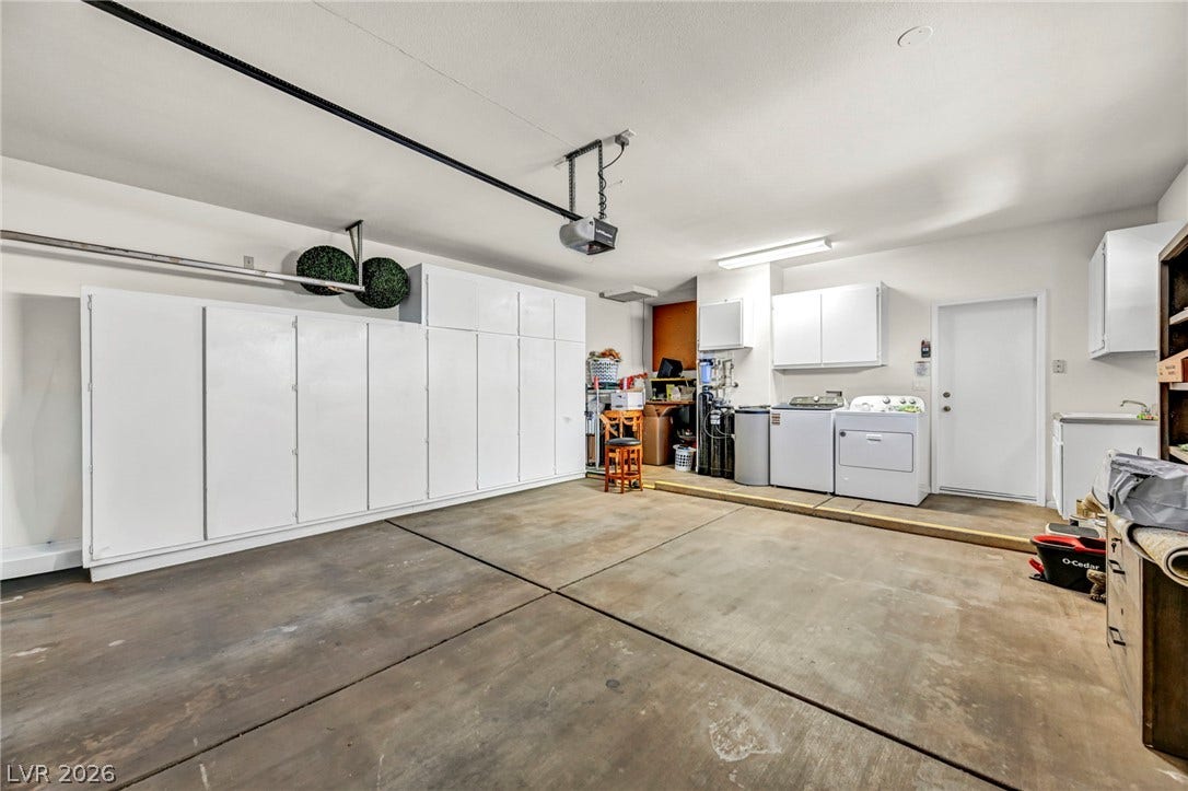 10020 Villa Ridge Drive, Las Vegas, NV 89134 An accommodating garage features concrete flooring, integrated storage cabinets, and dedicated utility connections.