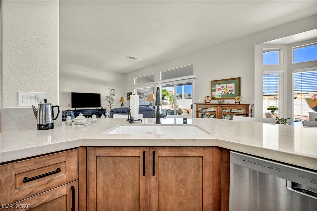 10020 Villa Ridge Drive, Las Vegas, NV 89134 Gleaming stone countertops and wood cabinetry frame views of the adjacent living spaces.
