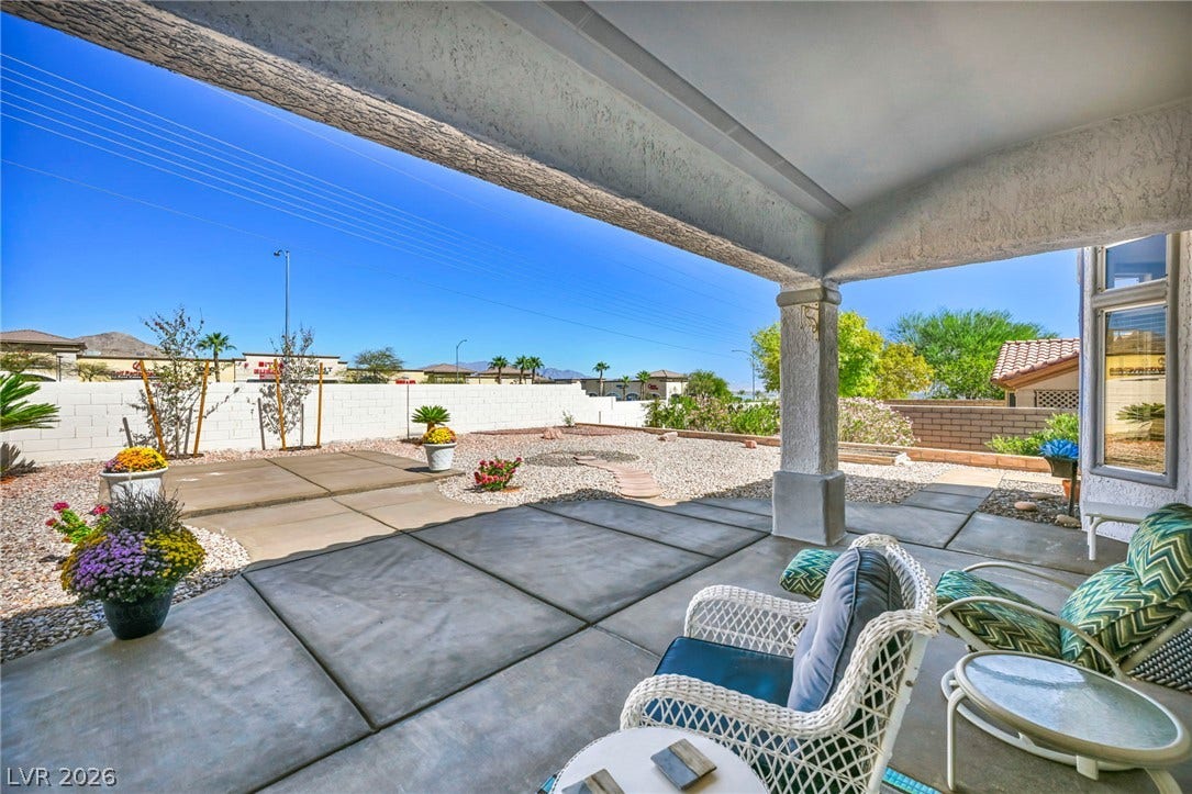 10020 Villa Ridge Drive, Las Vegas, NV 89134 Shaded concrete patio looks out over a low-maintenance gravel yard with perimeter wall privacy.
