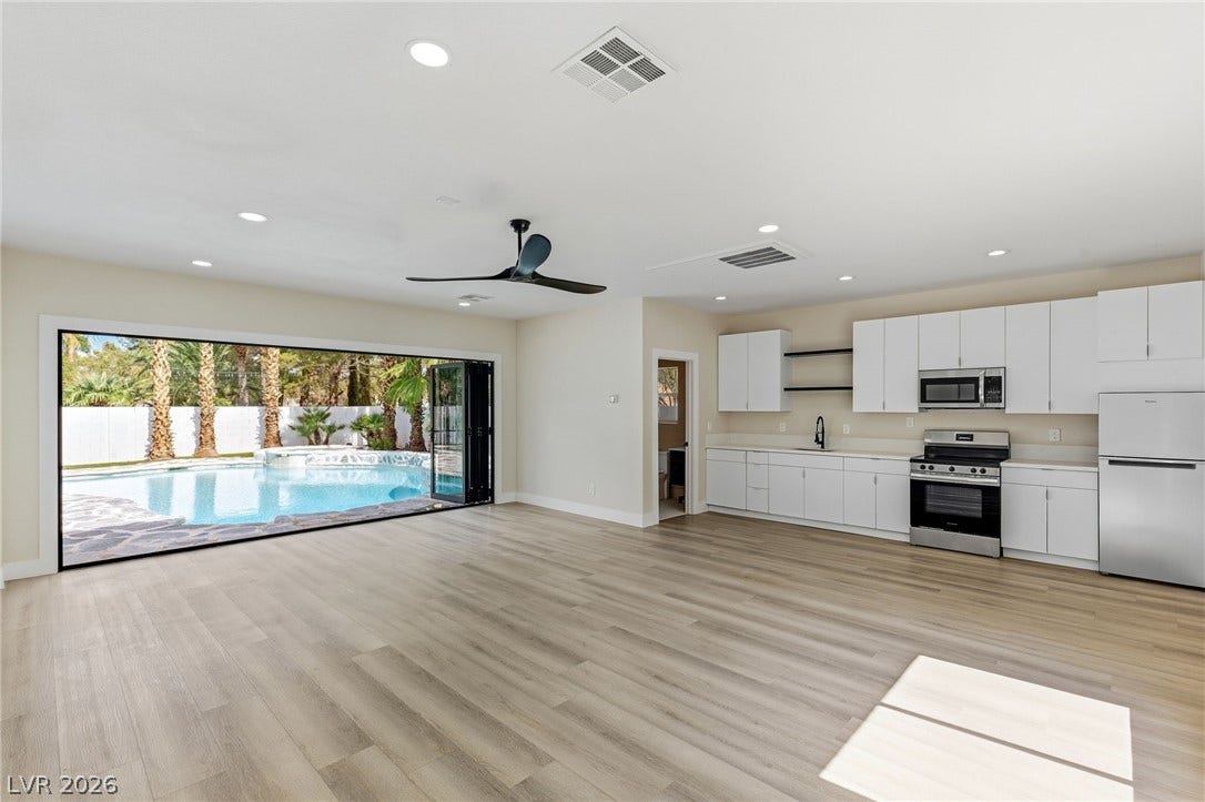10626 San Vercelli Court, Las Vegas, NV 89141 Retractable glass doors connect this open-concept kitchen and living area directly to the backyard pool.