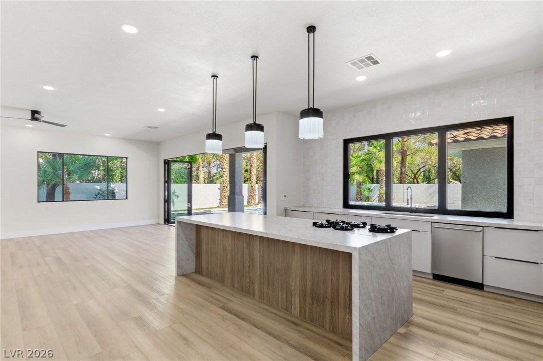 10626 San Vercelli Court, Las Vegas, NV 89141 Gleaming wood floors anchor an airy, open layout connecting the kitchen and living spaces.