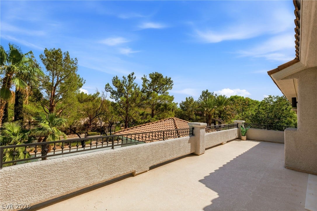 10626 San Vercelli Court, Las Vegas, NV 89141 An elevated perspective overlooks mature trees and neighboring rooftops from a spacious balcony.