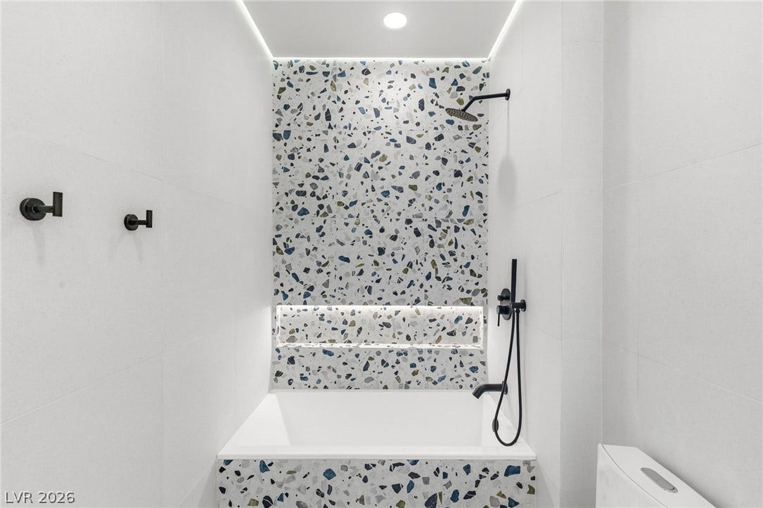 10626 San Vercelli Court, Las Vegas, NV 89141 Terrazzo style tiles and modern black fixtures create a contemporary bathing space.