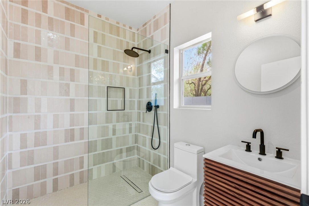 10626 San Vercelli Court, Las Vegas, NV 89141 Tiled walls and a glass partition define the walk-in shower of this updated bathroom.