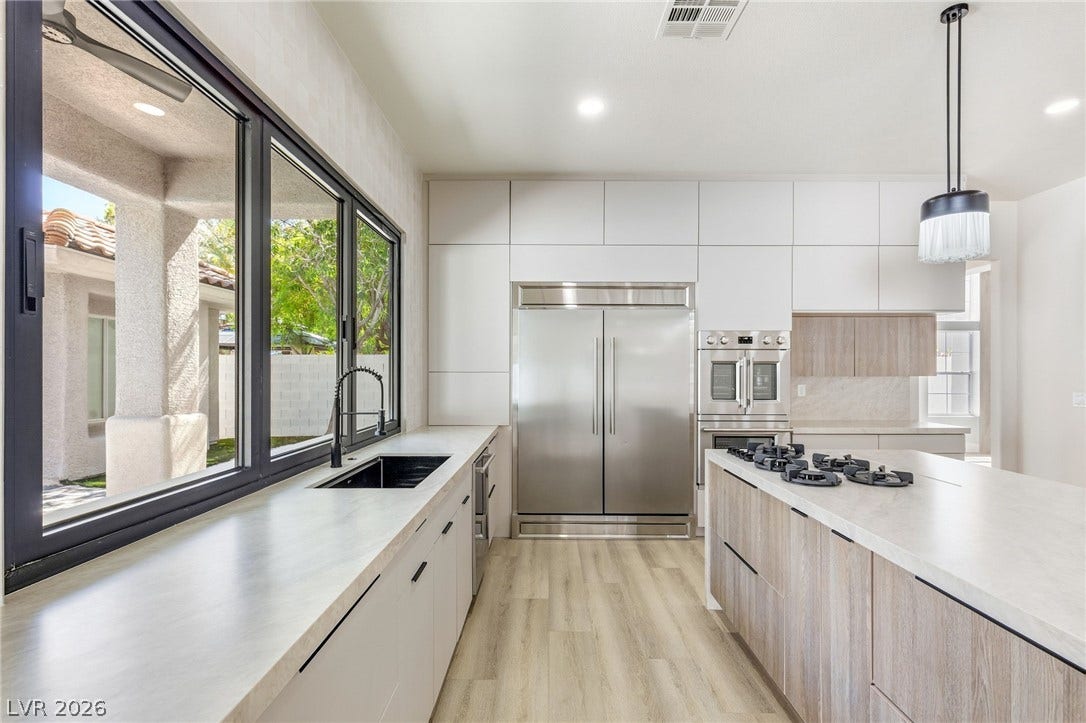 10626 San Vercelli Court, Las Vegas, NV 89141 Streamlined cabinetry and premium appliances define this light-filled modern kitchen space.