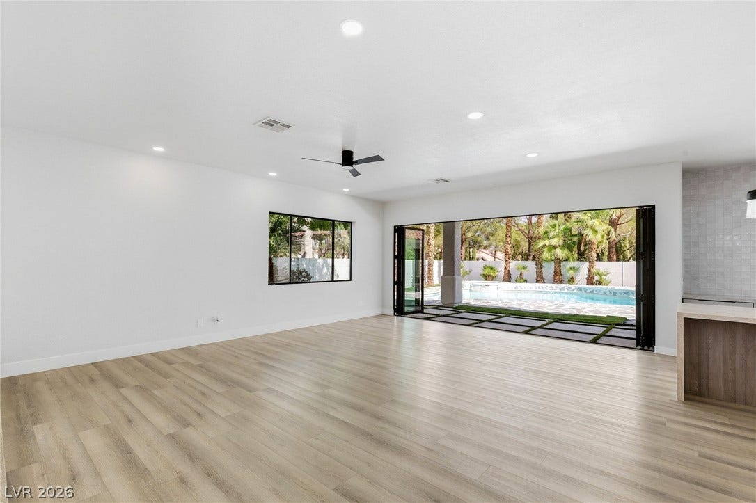 10626 San Vercelli Court, Las Vegas, NV 89141 A spacious interior features smooth wood flooring and massive sliding doors opening to the pool.
