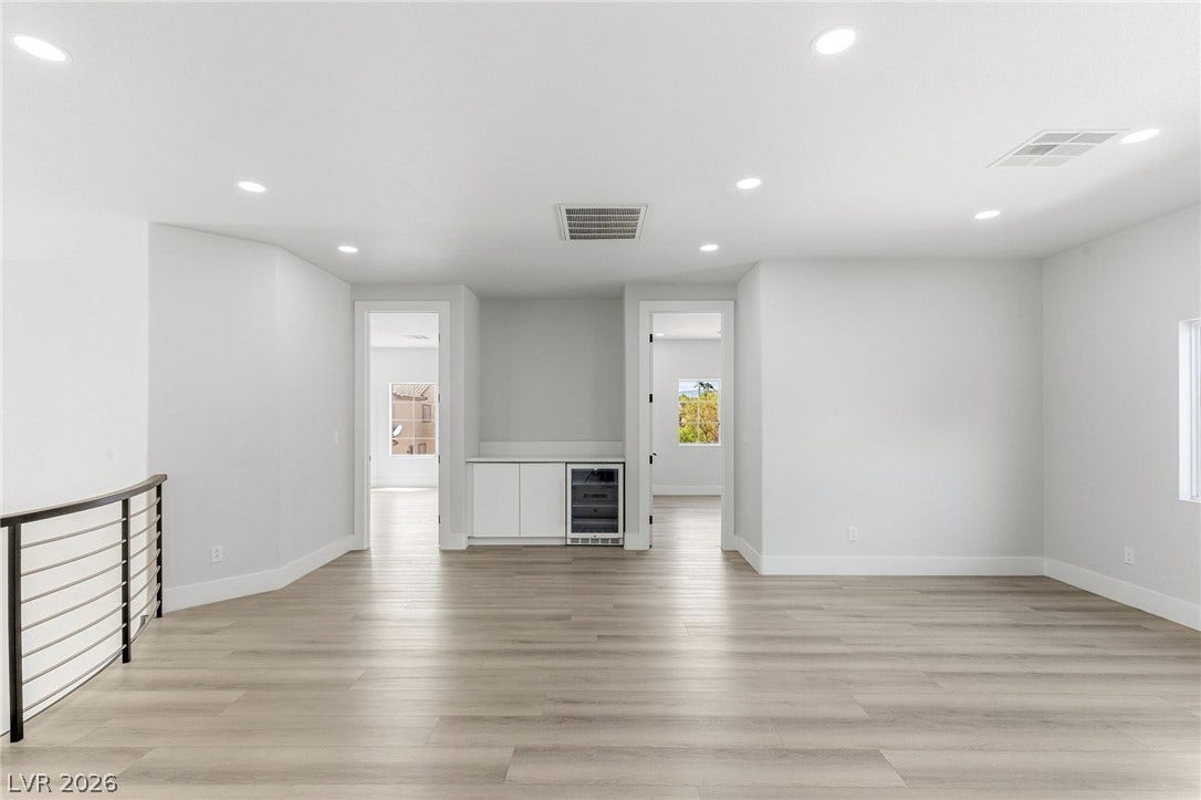 10626 San Vercelli Court, Las Vegas, NV 89141 Recessed lighting and luxury vinyl plank floors define this open upper-level landing with beverage bar.