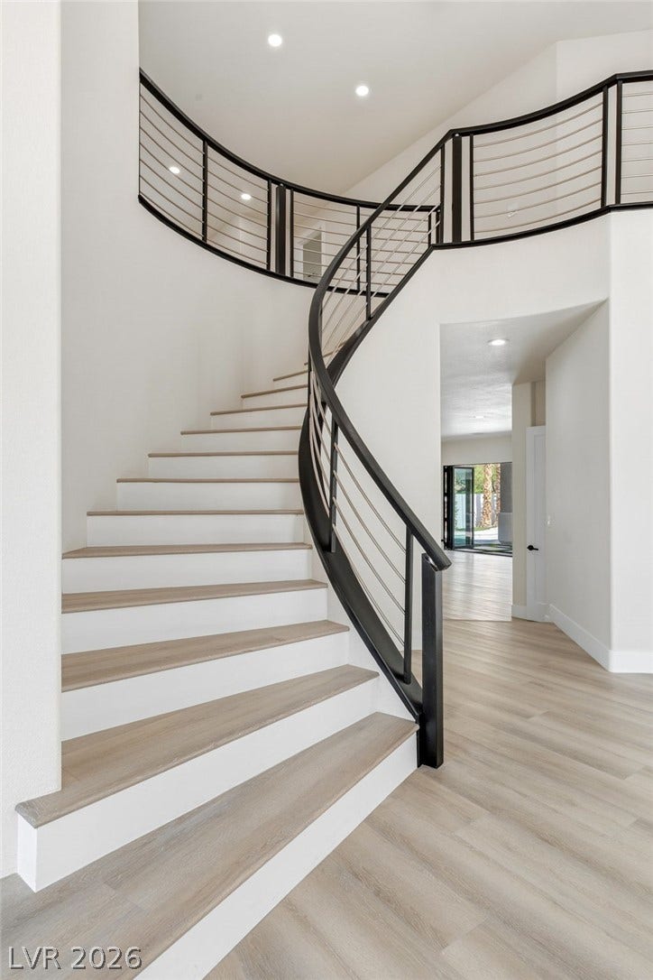 10626 San Vercelli Court, Las Vegas, NV 89141 A curved staircase with modern cable railings accents the entry of this home.