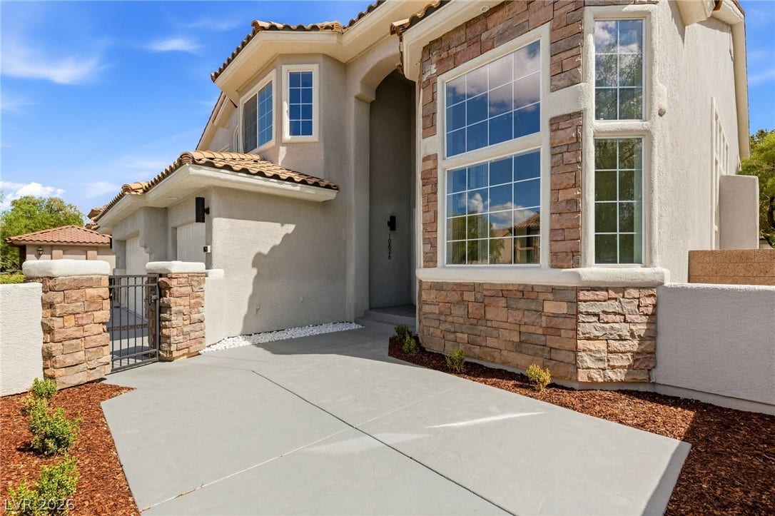 10626 San Vercelli Court, Las Vegas, NV 89141 Multi-pane windows and textured stone accents define the facade of this two-story home.