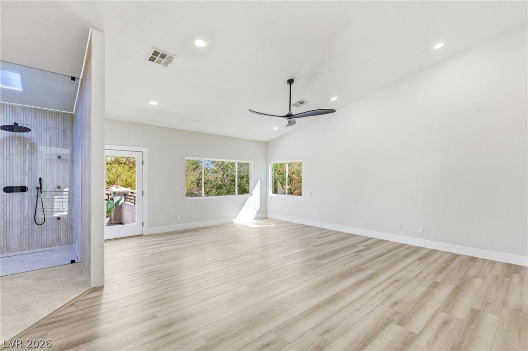10626 San Vercelli Court, Las Vegas, NV 89141 High ceilings and clean plank flooring define this airy primary suite with integrated glass shower.