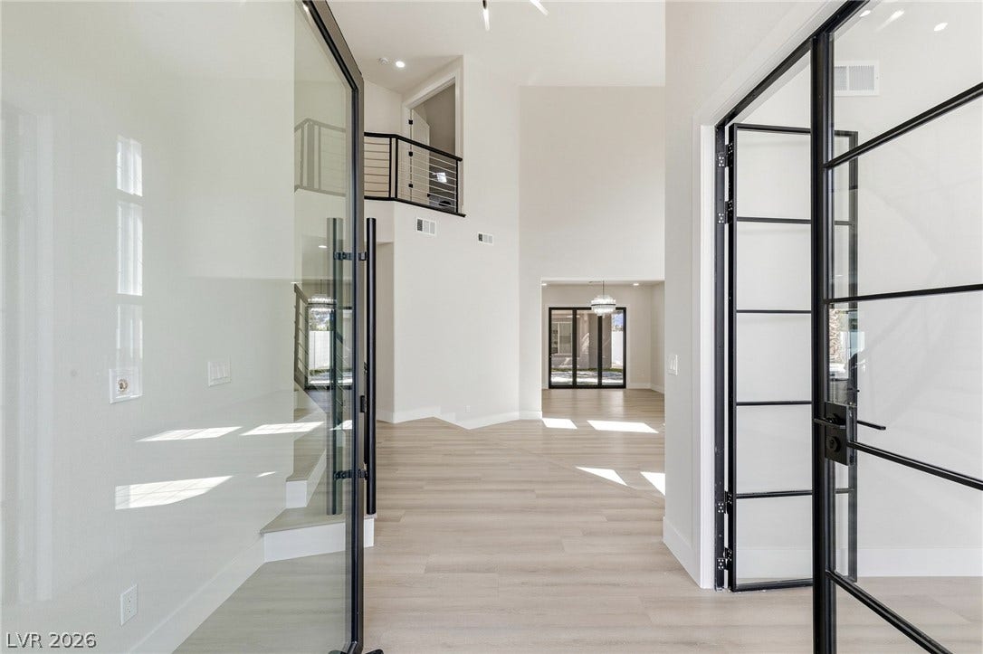 10626 San Vercelli Court, Las Vegas, NV 89141 Striking glass doors lead into a soaring foyer with light wood-style flooring.