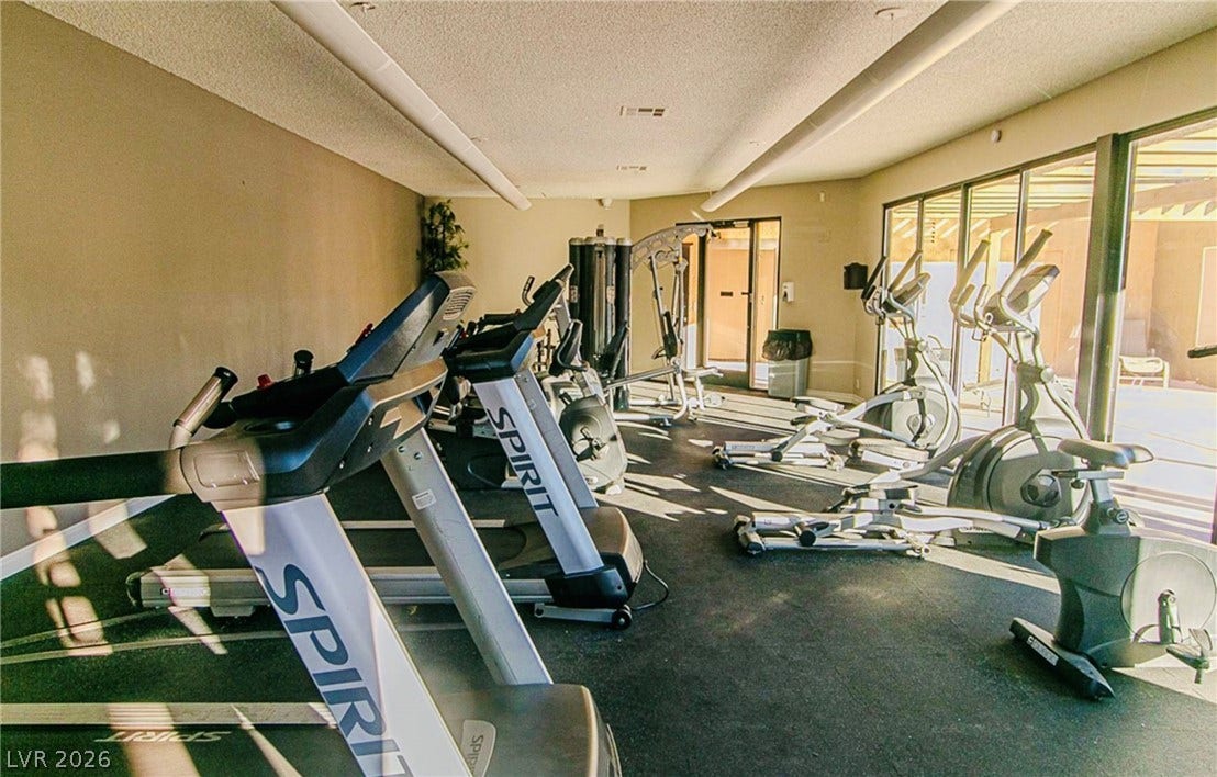 Floor-to-ceiling glass walls line this exercise room equipped with specialized sports flooring.