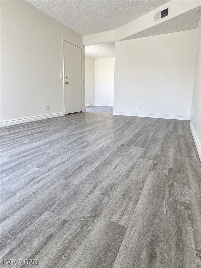 Modern plank flooring runs throughout this airy living space with high vaulted ceilings.