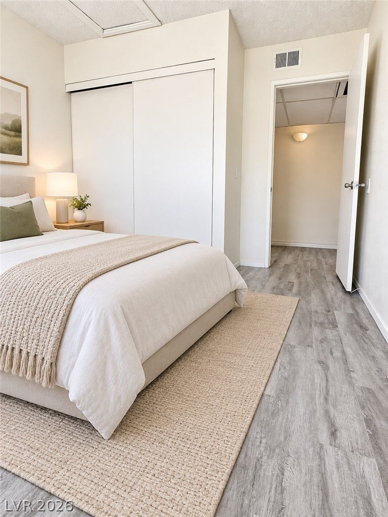 Virtually Staged Sleek wood-style flooring runs through this inviting bedroom featuring a wide closet.