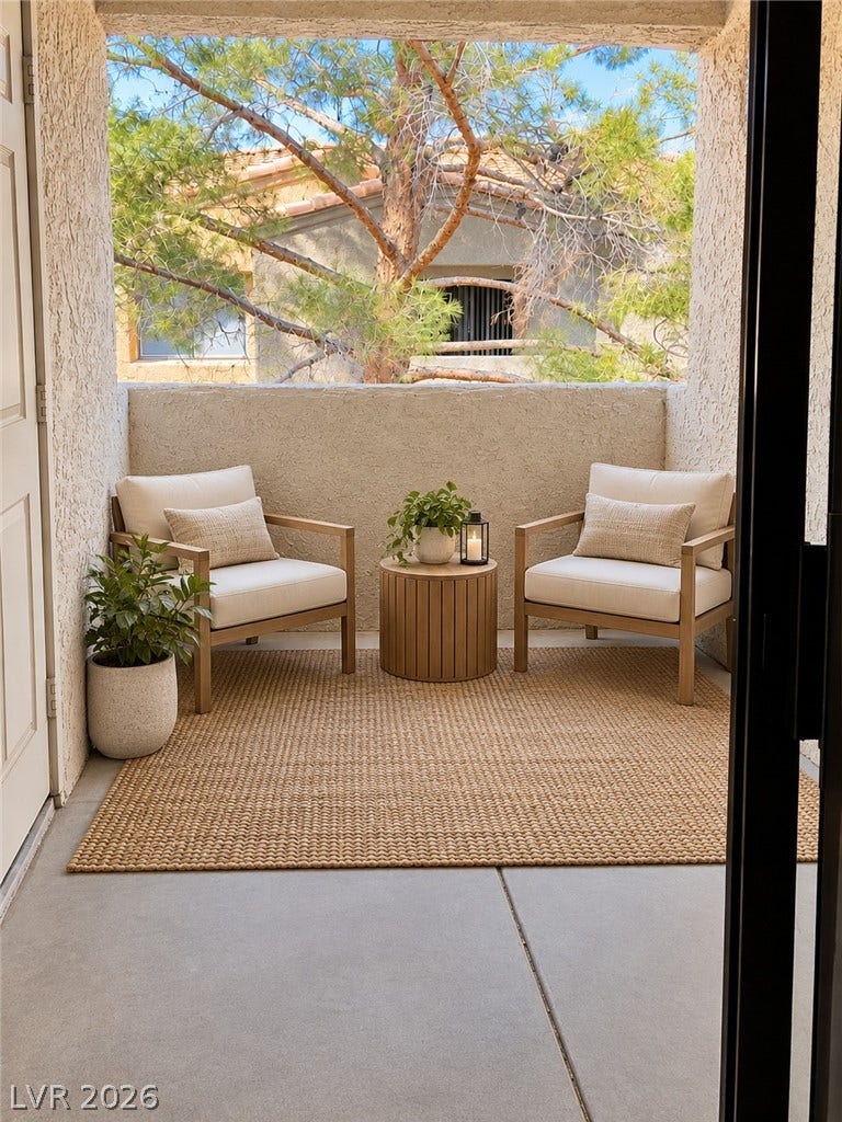 Virtually Staged Concrete flooring and textured stucco walls define this cozy private balcony.