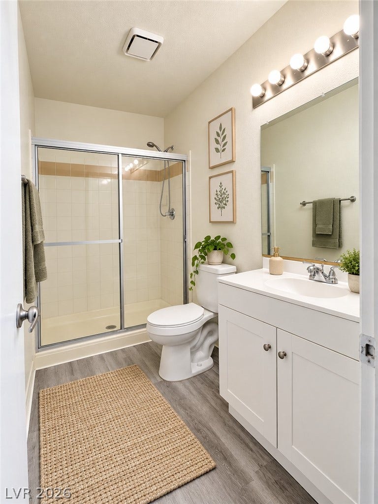 Virtually Staged 
A classic vanity and sliding glass shower door highlight this functional bathroom space.