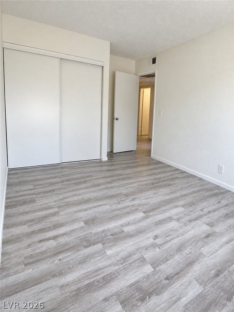 Modern plank flooring and a spacious sliding-door closet define this versatile bedroom.