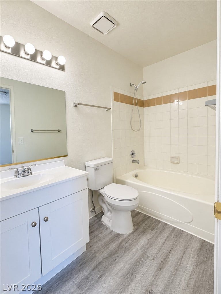 Clean lines and durable finishes define this functional bathroom with updated wood-look flooring.