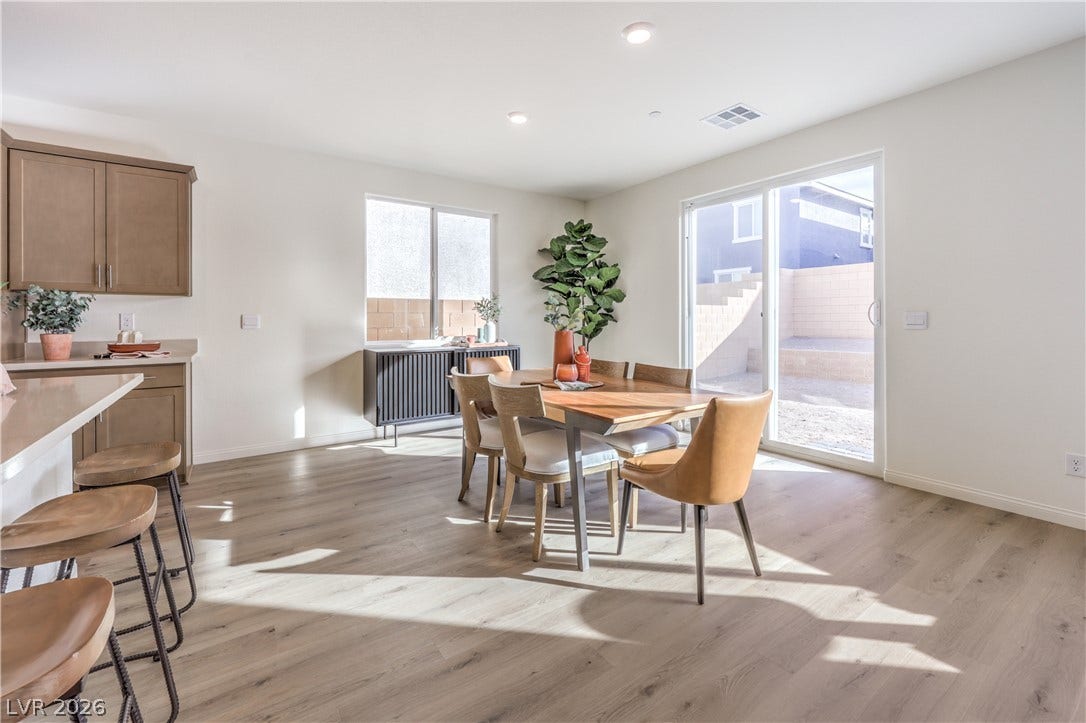 568 Ivory Peacock Ct, Henderson, NV 89011 Natural light pours across the open dining area and onto the smooth wood-look flooring.